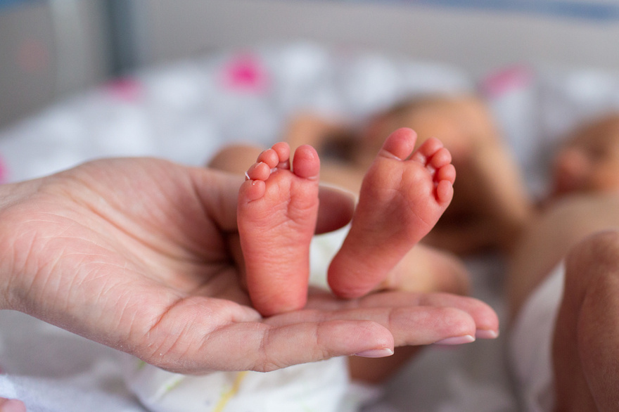 Young boy helps dad to keep his newborn twin siblings warm in viral photo